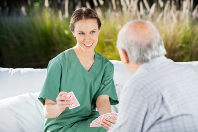 caregiver playing cards with senior man